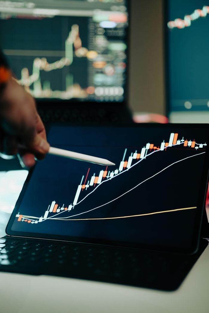 About Close-up of a digital tablet showing a financial growth chart with graphs and trends under analysis.