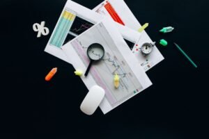Home-test Overhead view of an office desk with financial documents, a magnifying glass, and stationery items, suggesting business analysis.