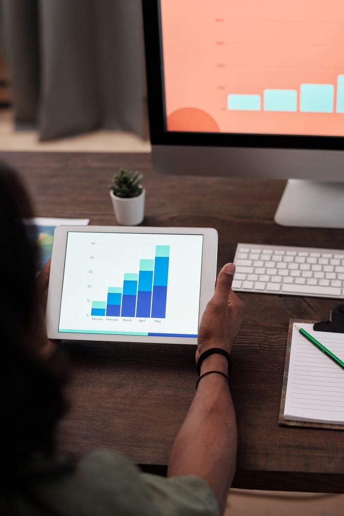 The Art of Drawing Readers In: Your attractive post title goes here A person reviews statistical graphs on a tablet, showcasing data analysis and technology.